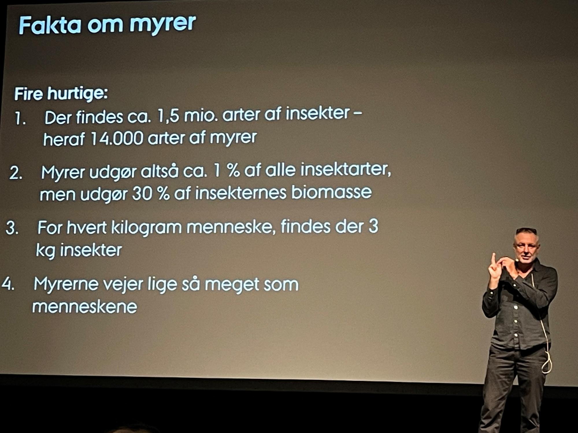 Joachim på står på scenen og fortæller facts om myrer