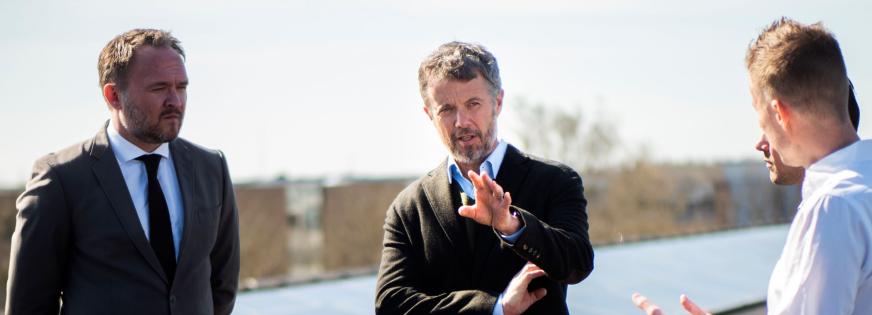 Kronprinsen og klimaministeren står på et tag med solceller