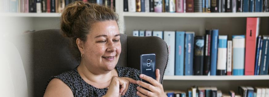 Kvinde kigger på en mobiltelefon