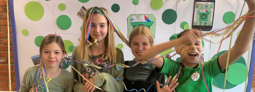 Fire glade elever med konfetti kigger ind i kameraet