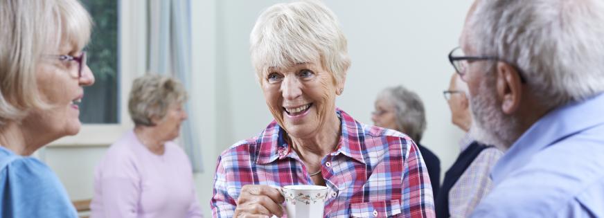 Tre seniorer drikker kaffe