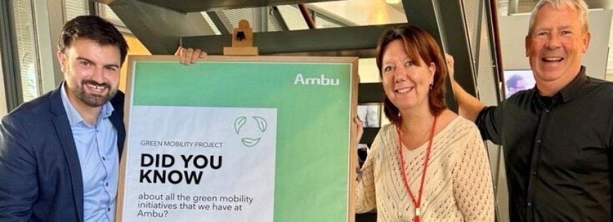 Tre personer står ved en tavle