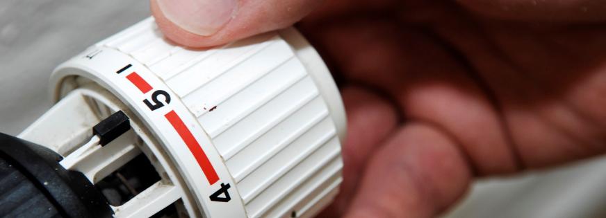 Hånd skruer på termostat