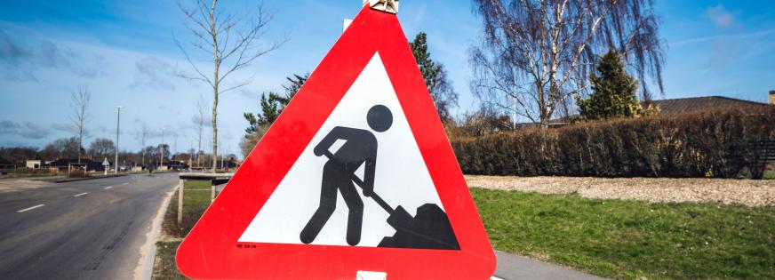 Vejskilt, der viser mand med en skovl, der graver