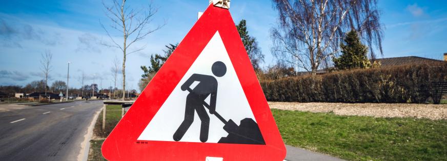 Vejskilt, der viser mand med en skovl, der graver