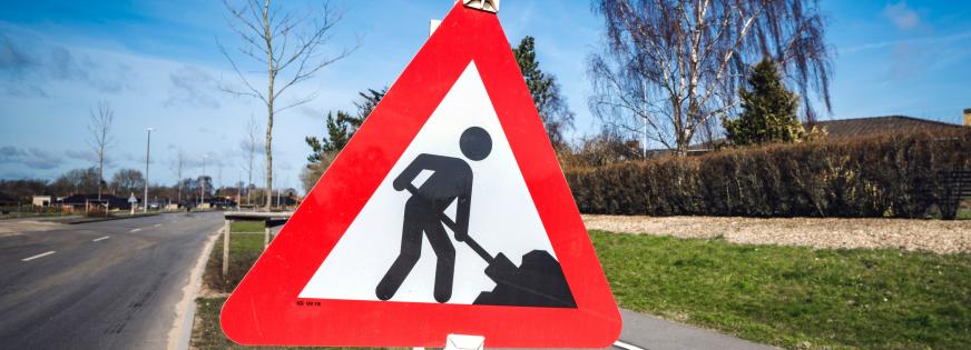 Vejskilt, der viser mand med en skovl, der graver